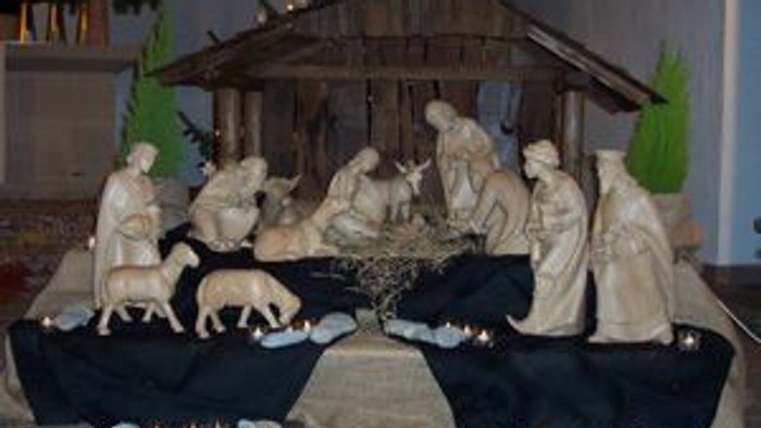 Die Krippe zeigt die Geburt Jesu mit Maria, Josef und dem Kind in der Krippe, umgeben von Tieren und Engeln.