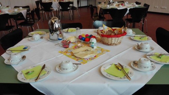 Mit Kaffegedecken und Osterschmuck gedeckte Tische im Paul-Schneider-Saal