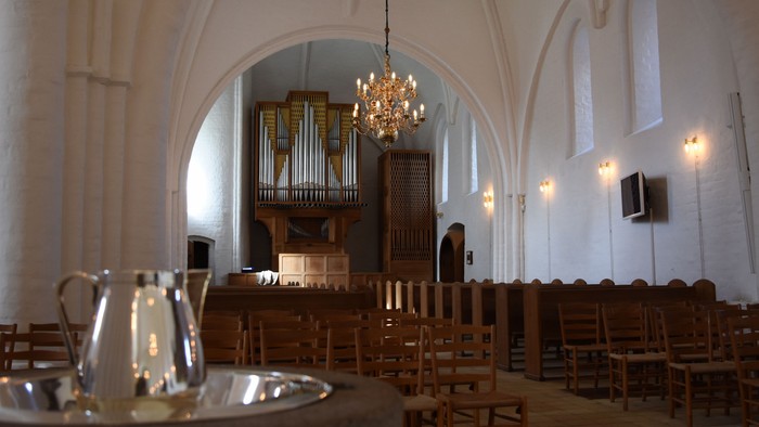 Inden i kirke med orgel og kandlelygte