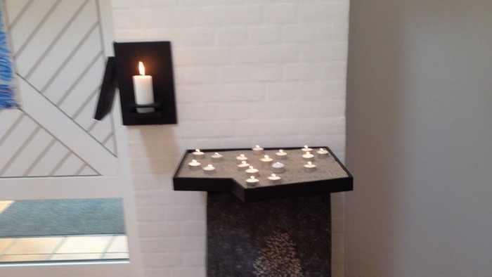 En sort bord med lys på et hvide væg