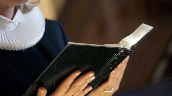 En person holder en håndskrevet bog.