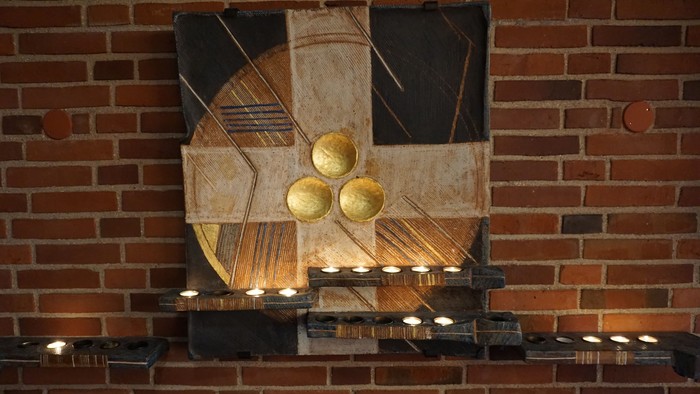 Abstrakt kunstværk med gyldne kugler på murstensvæg