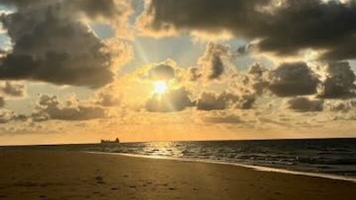 Sonnenuntergang über dem Ozean mit Wolken.