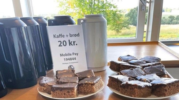 Kaffe og kage udstillet med pris og betalingsinformation