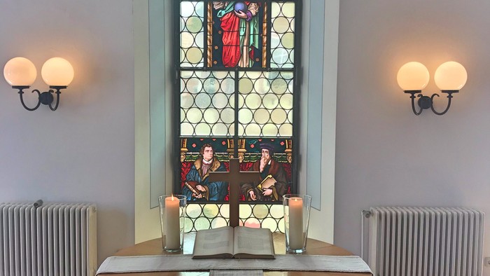 Ein Kirchenaltar vor einem buntglasfenster