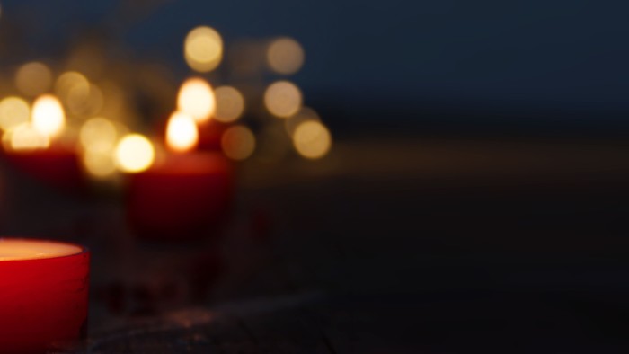 Mehrere brennende Kerzen in der Dunkelheit