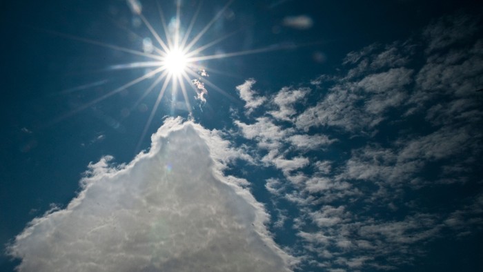 En solskin bag en hvid skyer.