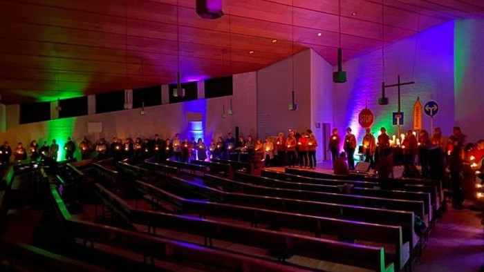 Eine Kirche mit bunten Lichtern und vielen Menschen.