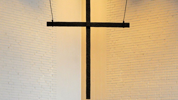 Ein schwarzes Kreuz an einer weißen Ziegelwand