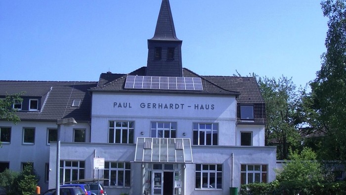 Das Paul Gerhardt Haus mit Kirche und Solarpanels vor blauem Himmel