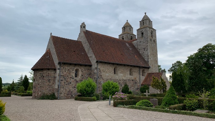 Det gamle stenkirke med spisse tårne og røde tag.