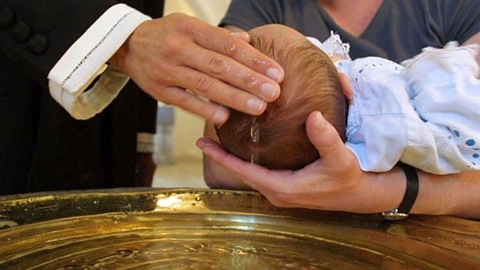 En person holdes et barns hoved under vand i en kommandopokale.