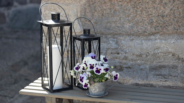 To benk med to lysestake og en blomsteraft.