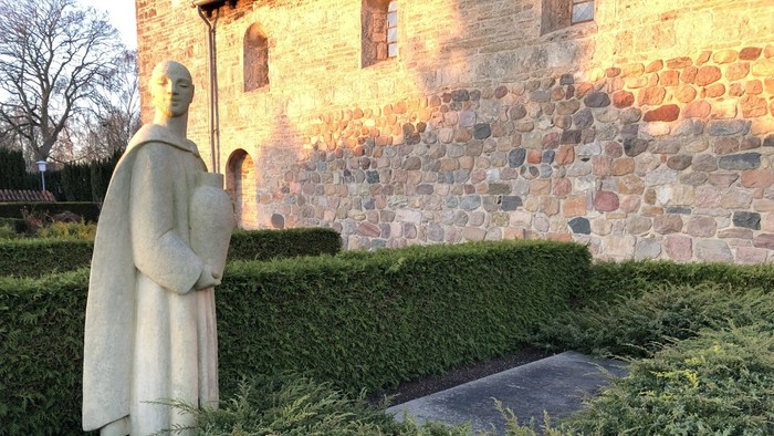 En stenstat af en munch ved en murstensmuret væg