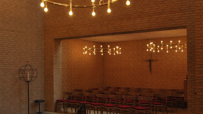 En lyssæde kirke med træbænke og lysstøb.