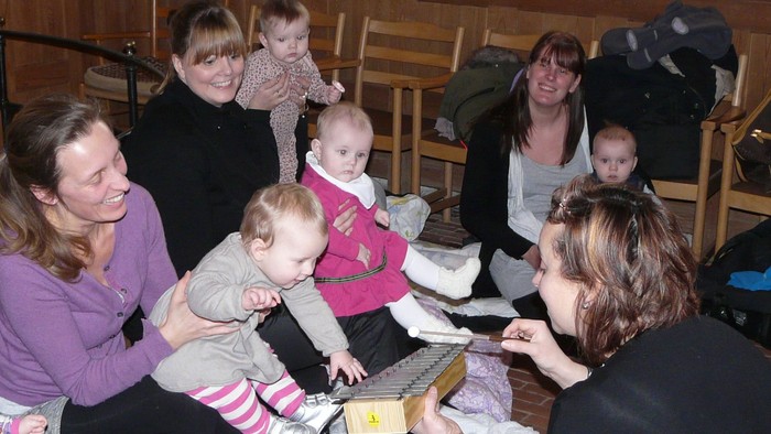 En gruppe af kvinder og børn sidder om en bord og spiser.