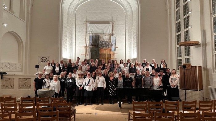 En stor gruppe af mennesker samlet i en kirke, der tager et samlet foto.