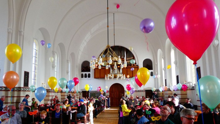 En kirke med mange børn med balloner.