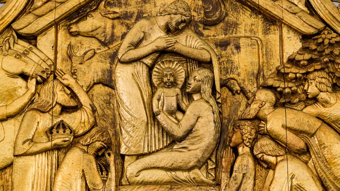 Billedet viser en udskåren scene med flere figurer i en hytte.