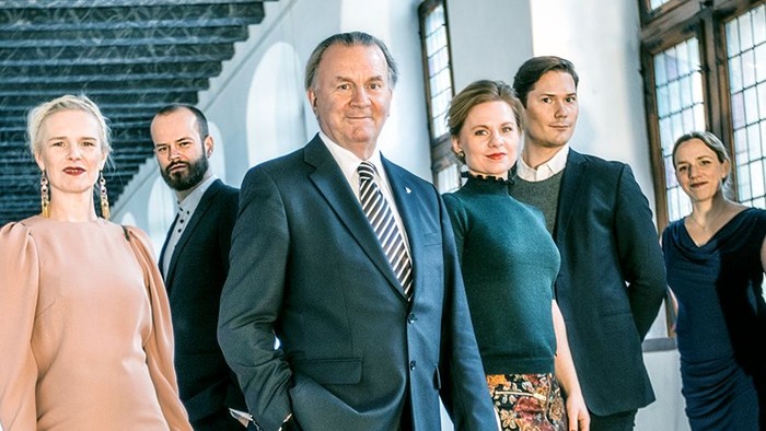 En gruppe forretningsfolk, der poserer sammen i et kontormiljø.