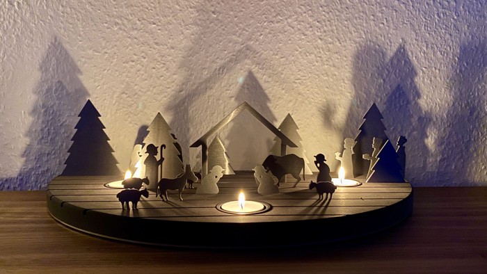 Eine Miniatur-Naturszene mit beleuchteten Tieren und Bäumen auf einem Holztisch