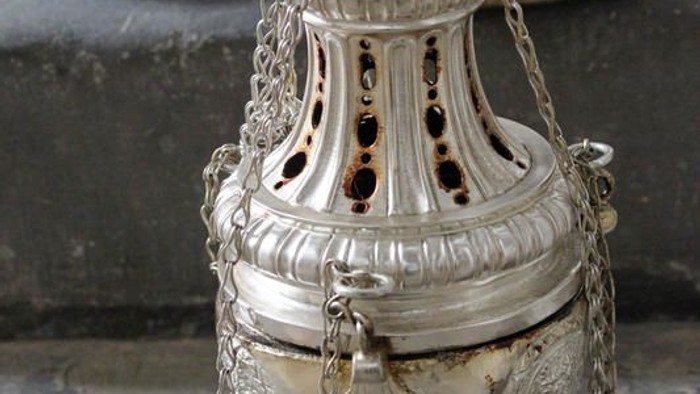 Silberner Weihrauchbrenner mit Ketten auf einer Steinfläche