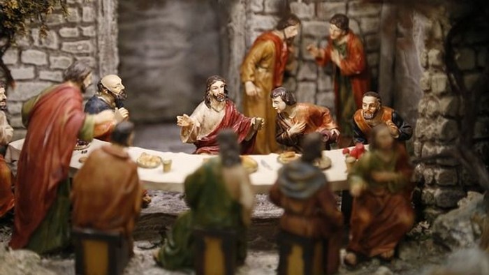 Eine Krippe mit mehreren Figuren, die um einen Tisch versammelt sind.