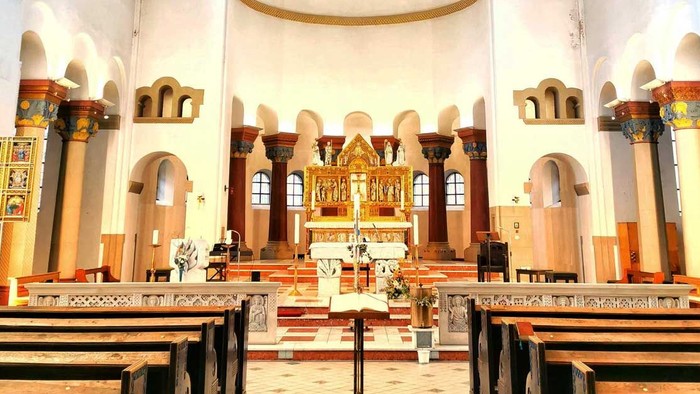 Innenraum einer Kirche mit Kreuz und Kirchenbänken