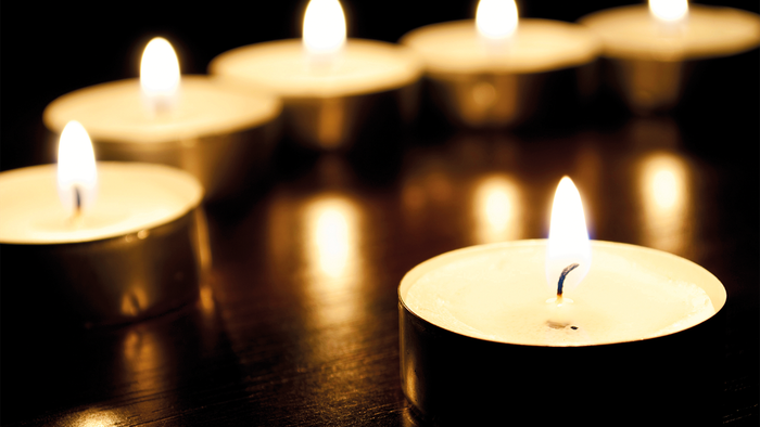 En række lysende lysekøn med blå flammer på en mørk underlag