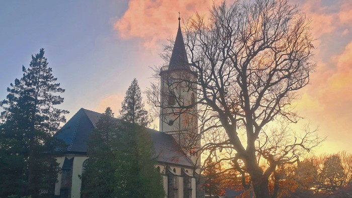 Kirche bei Sonnenuntergang mit Bäumen