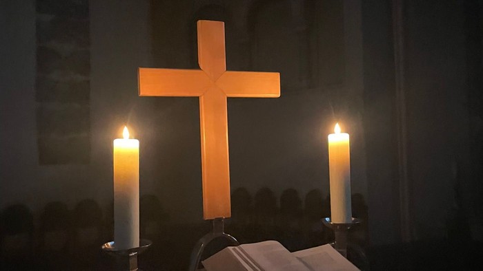 Ein Altar mit Kreuz, Kerzen und Bibel in einer Kirche