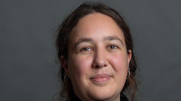 En kvinde med mørke hår og en sort trøje.