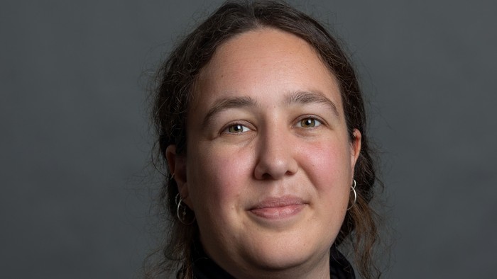 En kvinde med mørke hår og en sort trøje.