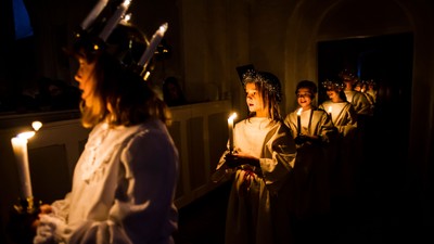 En gruppe børn i festlige kredenceremonier med lys.