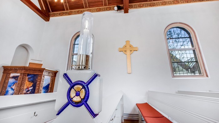 Indre del af kirke med alter, kors og vinduer