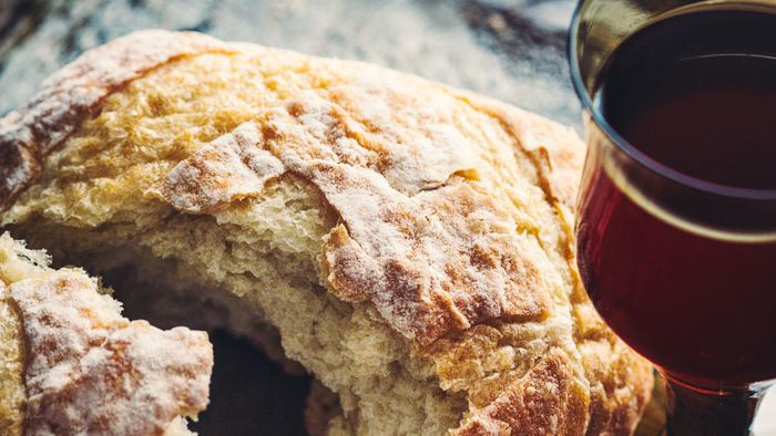 En stærk brød med en skål rødvin på siden