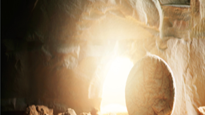 Et lys skiner ind i en grottekammer med en stor sten rullet til side