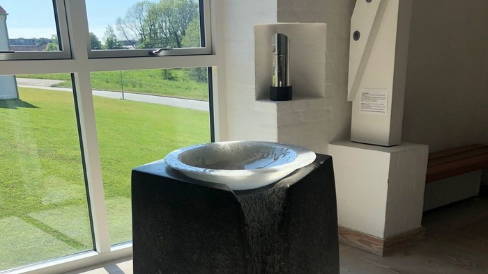 En moderne, sort keramikvaskeplade i et lys og moderne bad.