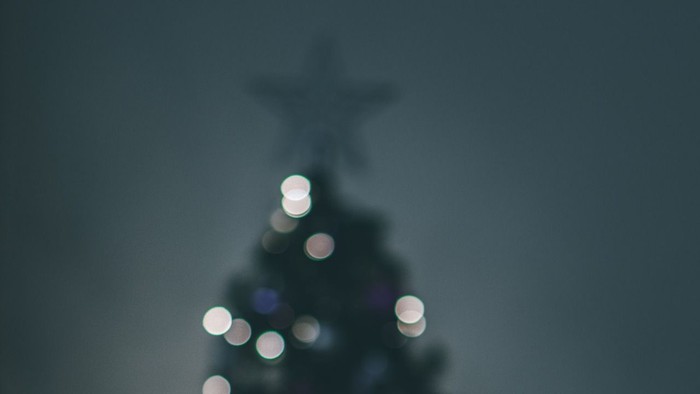 Et sløret juletræ med lys og en stjerne i toppen.