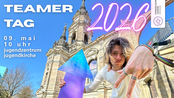 Junger Mann vor dem Jugendzentrum Jugendkirche, der mit einem Pfeil auf die Daten des Teamertags hinweist.