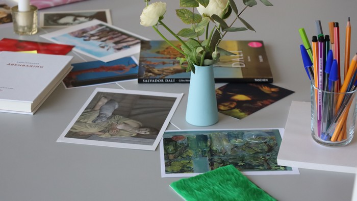 Bureau med blomster, billeder og skriveredskaber