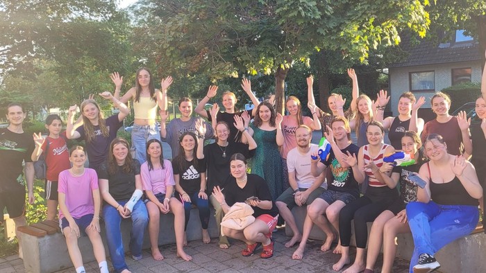 Eine Gruppe von Menschen feiert draußen gemeinsam