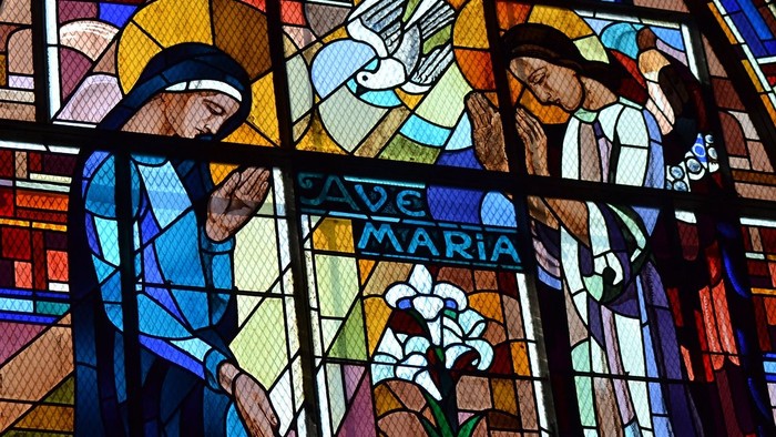 Glasmosai i kirke, der viser englen Gabriel, der besøger Jomfru Maria og bebuder Jesu fødsel 