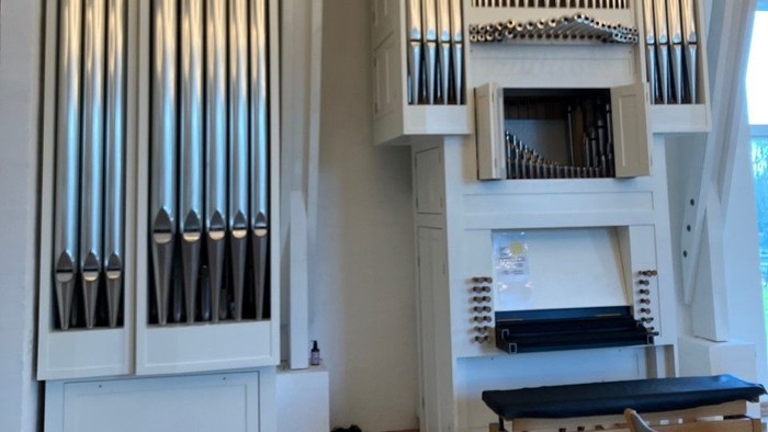 Stor hvid orgel i lys og rummelig rom