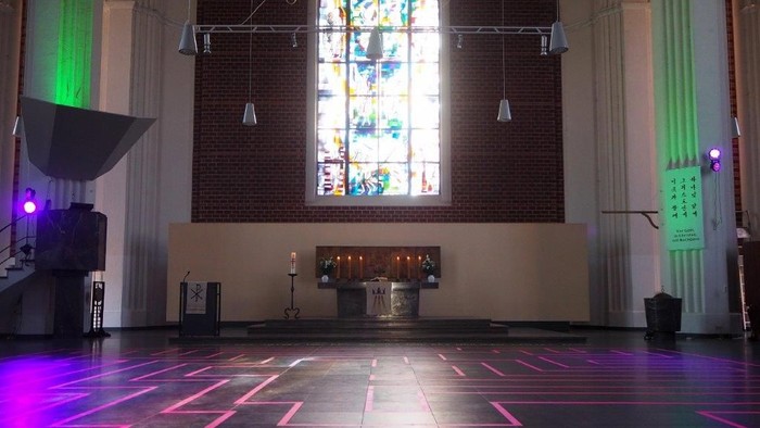 Die Kirche ist mit bunten Lichtern und einem großen Buntglasfenster geschmückt