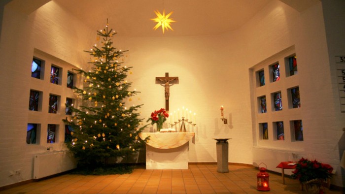 Weihnachtsdekoration in Kirche mit Christbaum und Kreuz