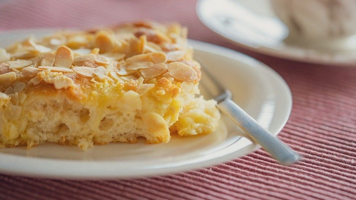 Ein Stück Kuchen mit Mandeln auf einem Teller