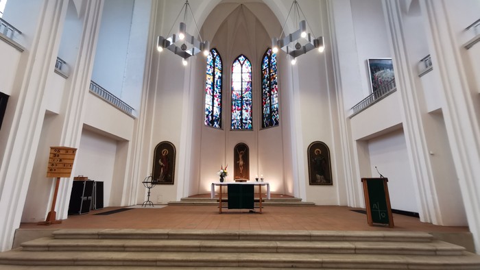 Die Kirche mit hohem Altar und bunten Glasfenstern