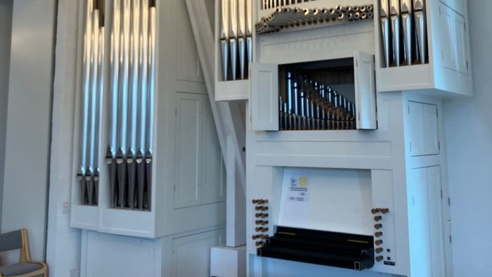 En stor orgel i et lys og rummeligt kirkerum