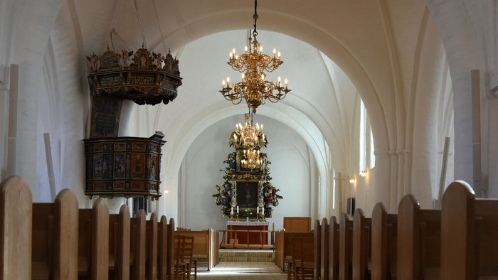 Indgang til kirke med høje vægge og belysning